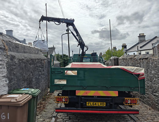 Skip Bag Hire Exeter. Full Skip bag and lifting crane in operation.
